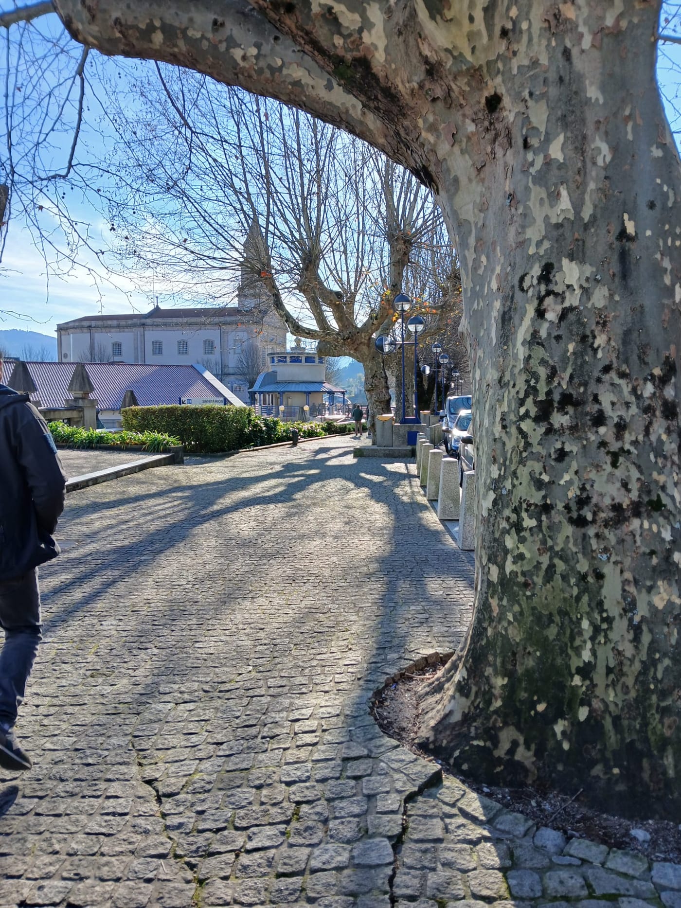 A rua da aldeia em granito, com o santuario ao fundo.