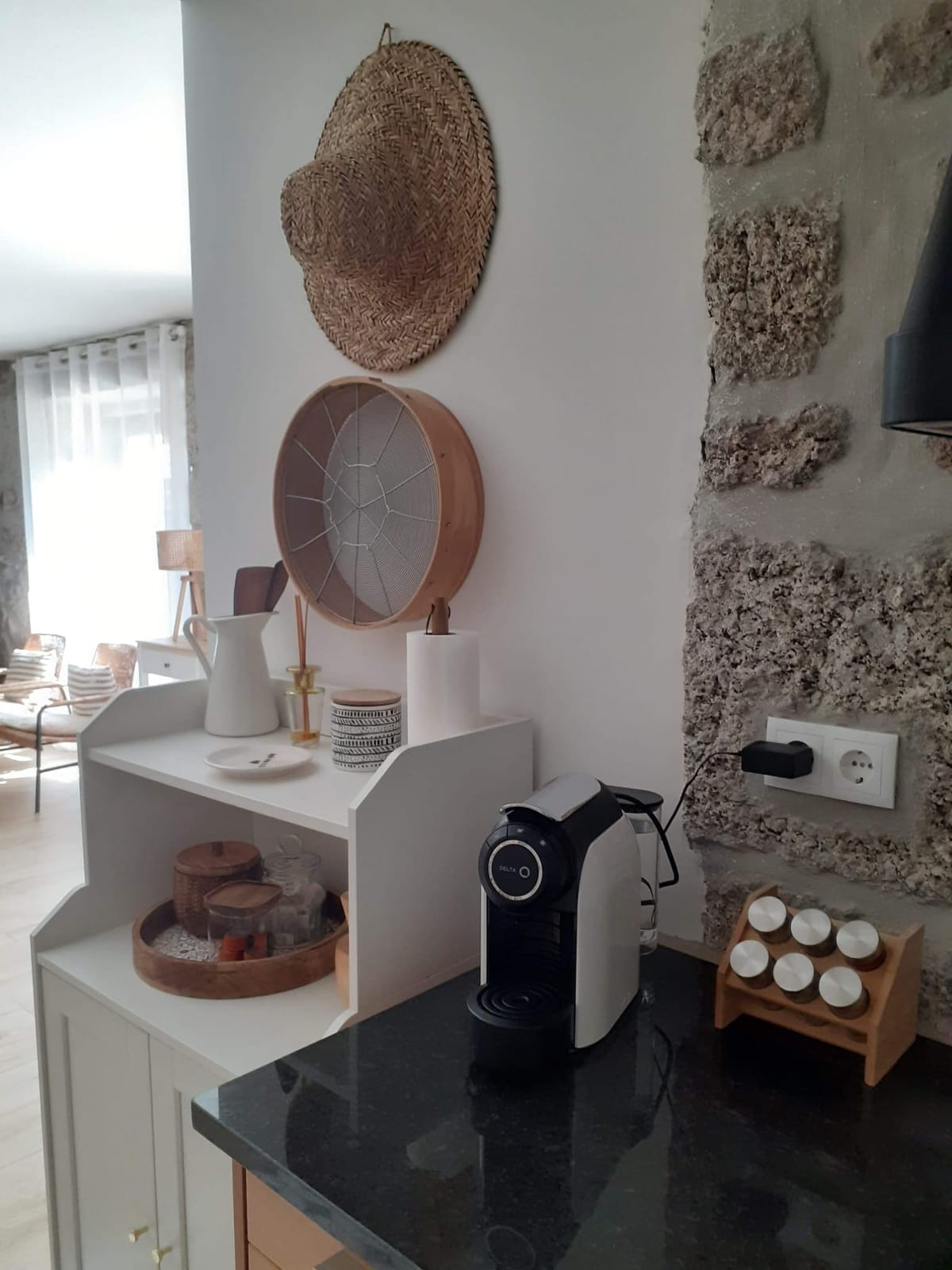 A cozinha, com a bancada em pedra e a parede de granito.