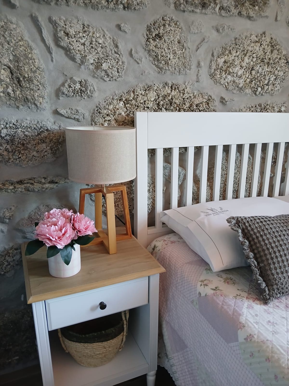 O Quarto Azul, com parede de granito e roupa de cama branca.